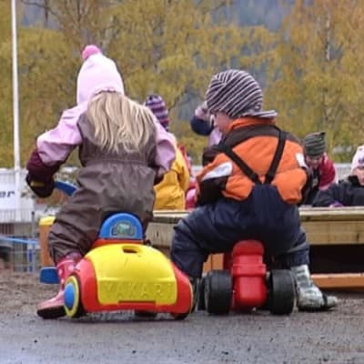 Barn leker på daghemsgården.