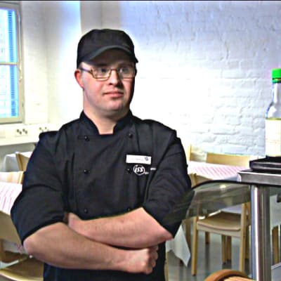Manlig restauranganställd i i lunchmatsal.