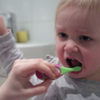 Lapsen hampaita pestään.