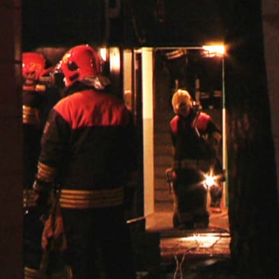 Brandmän i trapphuset i det branddrabbade höghuset i Nordsjö i Helsingfors.