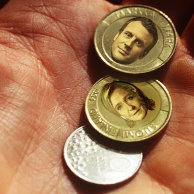 En redigerad bild med Emmanuel Macrons och Marine le Pens ansikten i finska marks mynt.