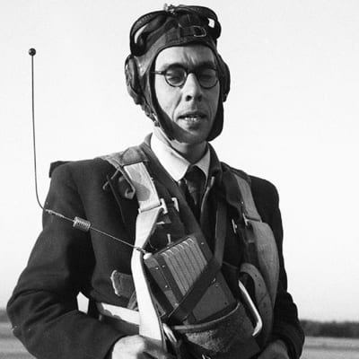 Usko Santavuori laskuvarjohyppääjän varusteissa mikrofoni rintaan kiinnitettynä (1950).