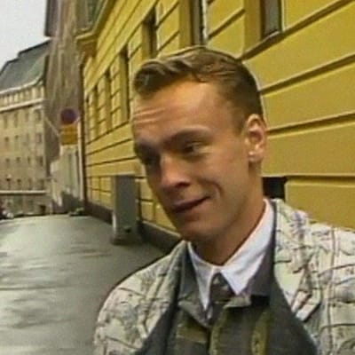 Juppi-kulttuurista kertovassa ohjelmassa Lauri Nykopp haastattelussa. 1980-luvun vaatteet yllään.