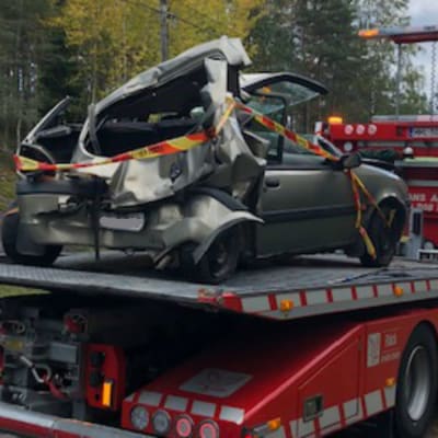 Bil som bogseras bort från olycksplats. Bakre delen av bilen förstörd.