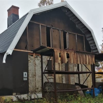 Vaasassa purku-uhan alla oleva keskeneräinen mansardikattoinen omakotitalo, jossa ei ole ulkolaudoitusta.