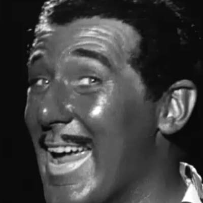 Näyttelijä Börje Lampenius laulaa viihdeohjelmassa mustaihoiseksi naamioituna (blackface).