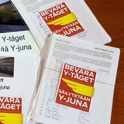 Plastfickor som innehåller namnlistor. Högarna är försedda med ett gulrött klistermärke med texten: Bevara Y-tåget.