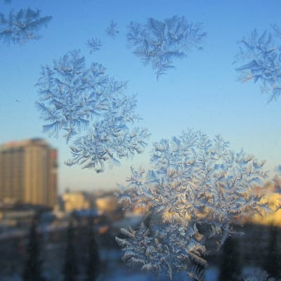 Lumikiteitä ikkunassa, taustalla Tampereen keskusta