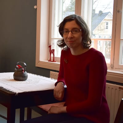 Nainen istuu pöydän ääressä joulukahvilassa