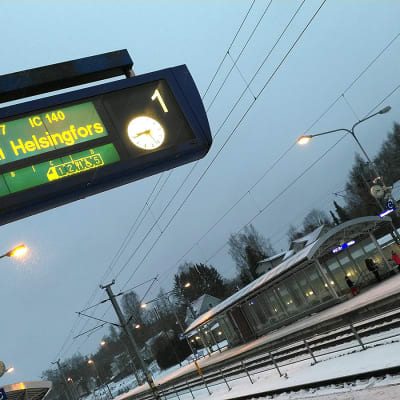 Hämeenlinnan juna-aseman raiteet ja opastaulu, joka kertoo junan olevan myöhässä