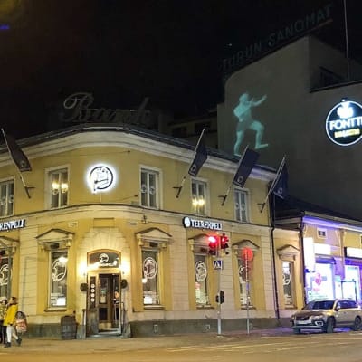 Ljuskonst med en stående man på Turun Sanomats byggnad på Köpmansgatan i Åbo.