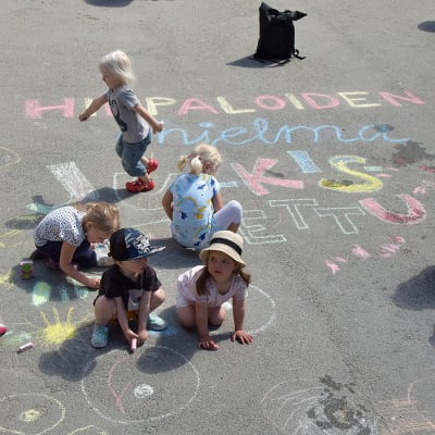 Lapset piirtävät asfalttiin.