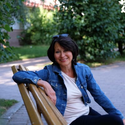 Monica Groop sitter på en parkbänk.