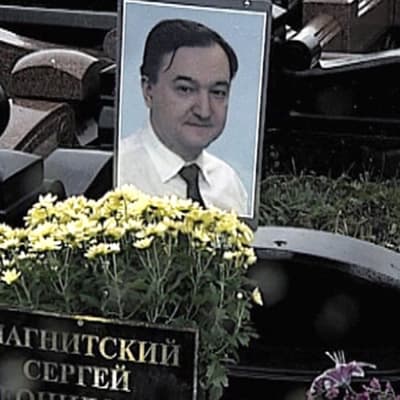 Sergej Magnitskij på bild vid en gravsten.