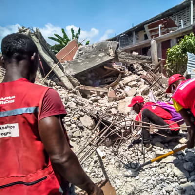 hjälparbetare gräver i rasmassor efter jordbävning