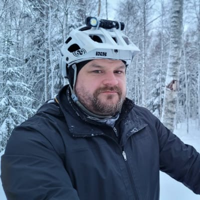 Man med skägg och cykelhjälm.