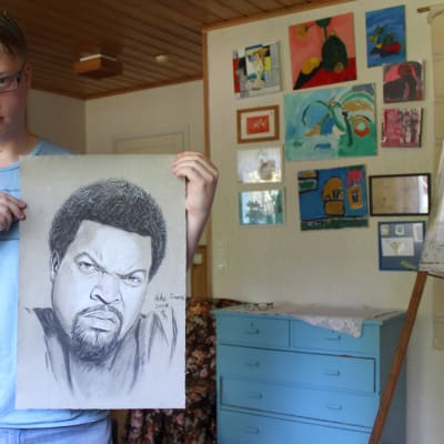 Akke Saari esittelee piirtämäänsä kuvaa muusikko Ice Cubesta.