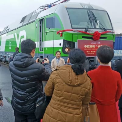 Människor och ett tåg på invigningen av godtågförbindelsen mellan Kouvola och Xi'an.
