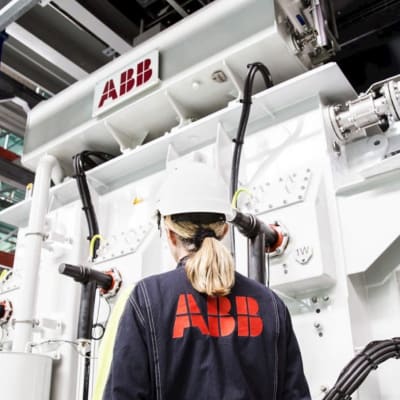 ABB-anställd i fabriken står framför en maskin.