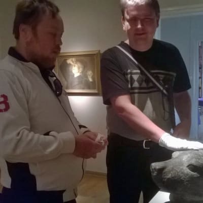 Patrik Paulin och Andreas Kanto känner på en skulptur föreställande ett sälhuvud.