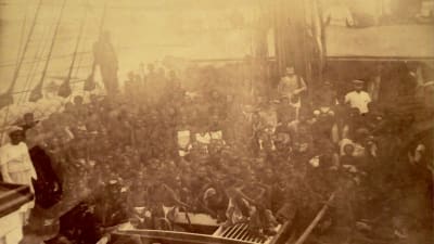Yhdysvaltoihin matkalla olevia orjia laivan kannella vuoden 1885 valokuvassa. 