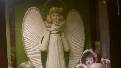 en ängel vaktar dockor i en säng