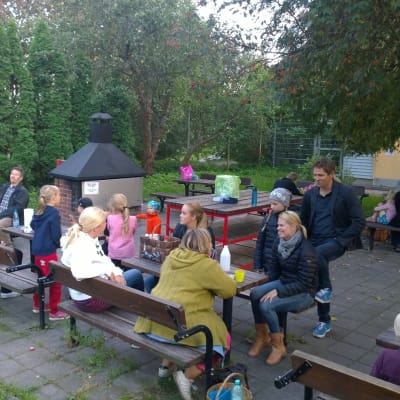 Personer sitter kring den låsta grillen i Kuppisparken.