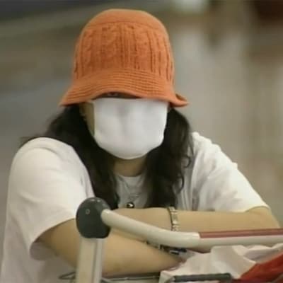 Nainen suojautuneena hengitysmaskiin Kiinassa 2003 SARS-epidemian aikaan