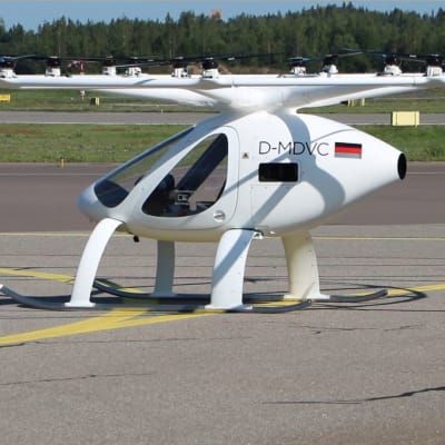 En vit elektrisk helikopter med 18 små rotorblad. 
