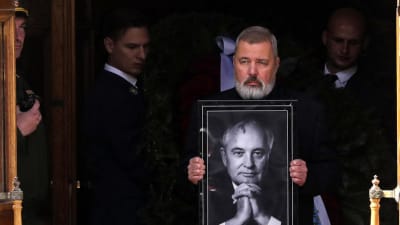 På bilden ses Novoja Gazetas chefredaktör Dmitrij Muratov hålla i en svartbild på den förra Sovjetledaren Mihail Gorbatjov. 
