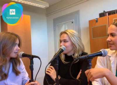 Tre unga kvinnor sitter vid varsin mikrofon.