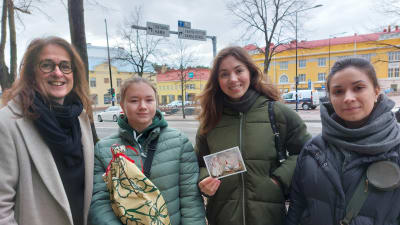 Fyra kvinnor på rad i centrala Borgå. Alla ler emot kameran. Tre av kvinnorna, de längst till höger, flyr undan Rysslands anfallskrig i Ukraina. 