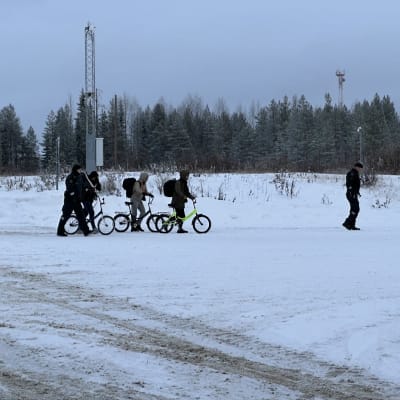 Tre personer som leder var sin cykel och två gränsbevakare vid östgränsen i Kuhmo 20.11.2023