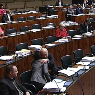 Erkki Virtanen och Silvia Modig omfamnar varandra under riksdagens debatt om jämlik äktenskapslag.
