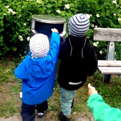 Lapset vievät roskia puhuvaan roskapönttöön.