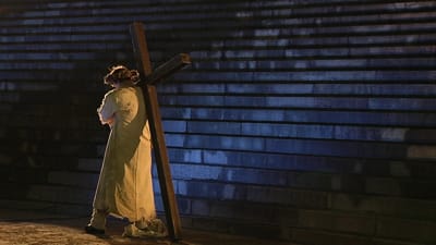 En man bär på ett kors. 