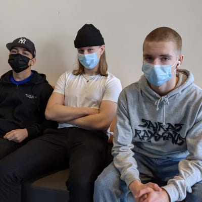 Aleksi Tarkiainen, Janne Käki ja Marius Pellinen istuvat Tikkurilan lukion aulassa. 