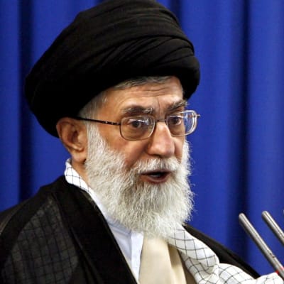 Iranin uskonnollinen johtaja Ali Khamenei puhuu mikkeihin.
