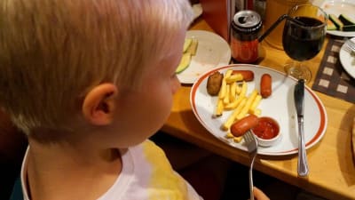 Barn äter barnportion på restaurang.