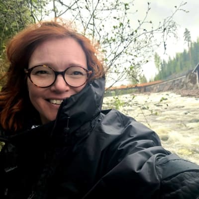 Mari Parkkinen seisoo kuohuvan Imatrankosken varrella. 