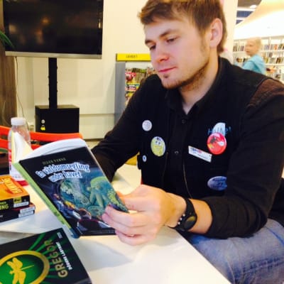 Bibliotekarien Mikael Gros bläddrar i barnböcker