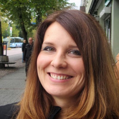 Pirjo Heikkilä hymyilee ja poseeraa Lahden Aleksanterinkadulla.