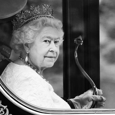 Drottning Elizabeth II i en vagn. Bilden är svartvit.