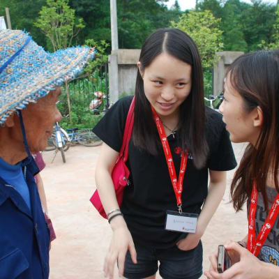 Wang Shuyan (i mitten) diskuterar med en kollega från Rädda barnen i Kina och en jordbrukare i en by i bergen i det sydvästliga landskapet Sichuan.