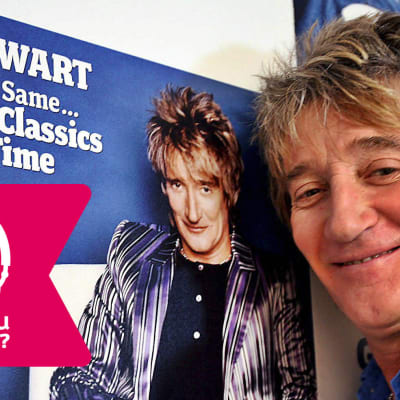 Rod Stewart ler framför en plansch av sig själv.