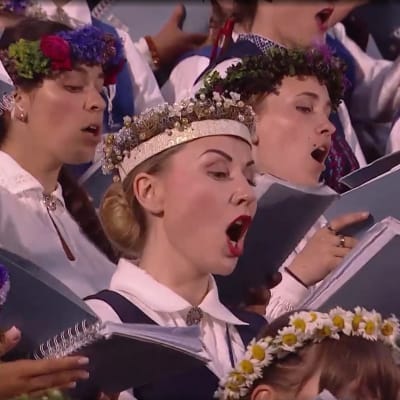 Kvinnor klädda i folkdräkt som sjunger i kör.