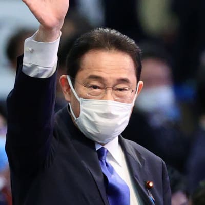 Den japanska politikern Fumio Kishida vinkar åt kameran. Han är iförd munskydd.