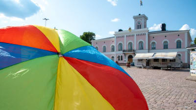 En prideflagga framför Lovisa stadshus.