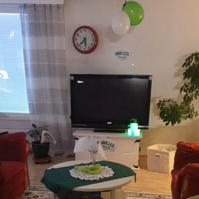 Ett vardagsrum inrett med Akilles-flaggor och gröna ballonger.