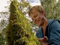 Susanna jobbar på en kon med mossa